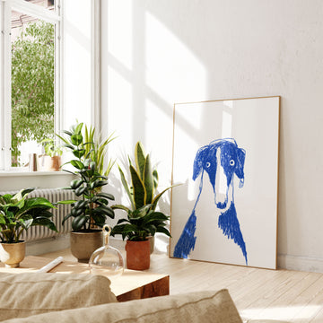 Blue and white dog head and shoulders drawing on white background resting on floor in sun room